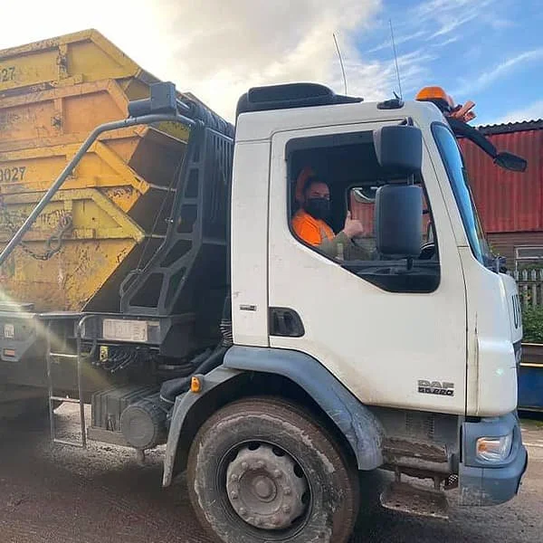 Urban team member in the white DAF skip truck with yellow skips